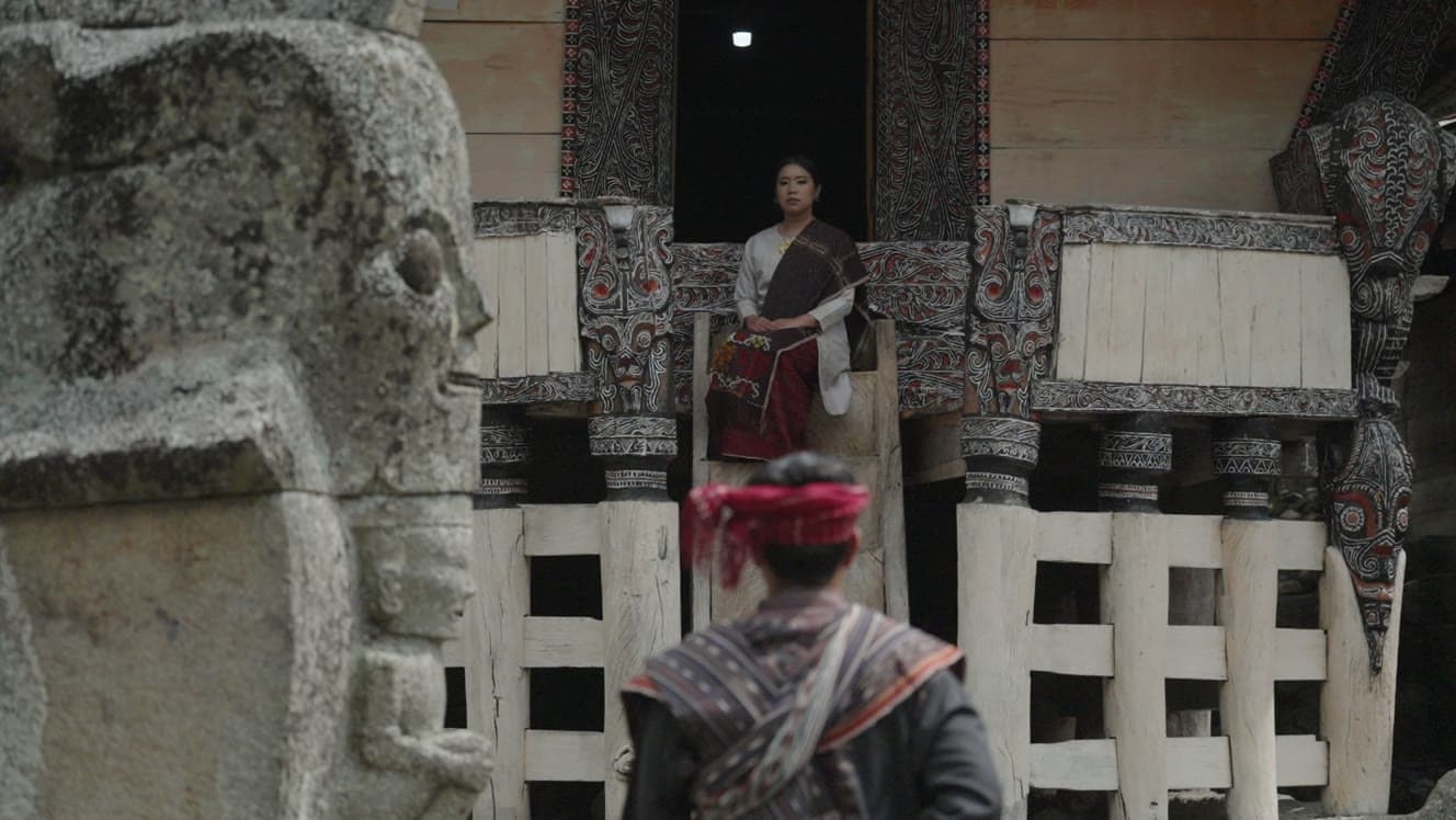 Traditional ceremony scene with a seated woman and a man in ceremonial clothing